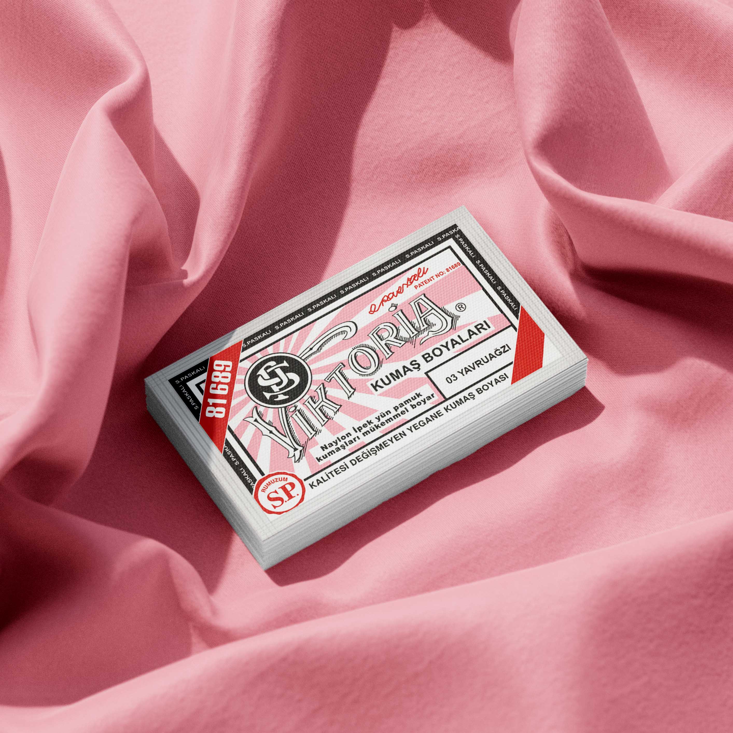 Pack of antique pink fabric dye placed on a vibrant pink fabric background