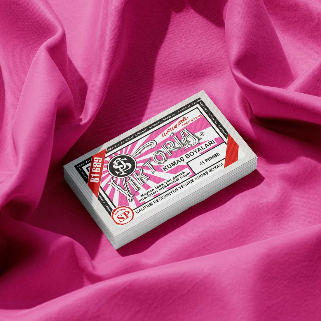 Pack of pink fabric dye placed on a vibrant pink fabric background